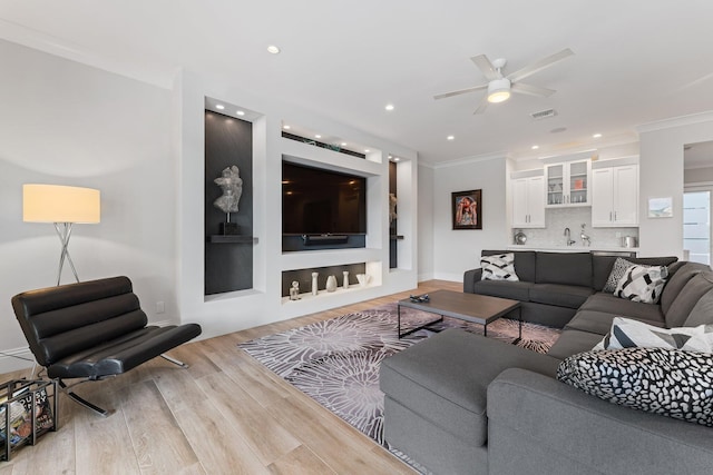 living room with ceiling fan, recessed lighting, wood finished floors, and ornamental molding