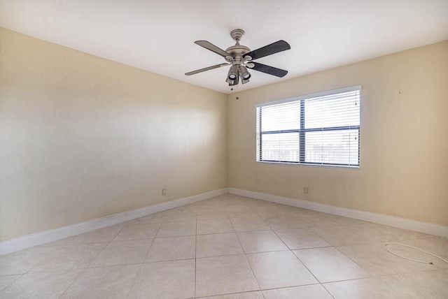 empty room featuring baseboards, a ceiling fan, and light tile patterned flooring