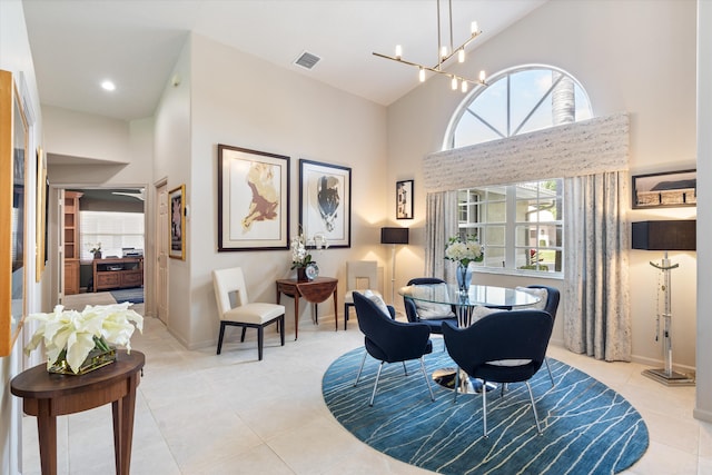 dining room with light tile patterned floors, a high ceiling, visible vents, and an inviting chandelier