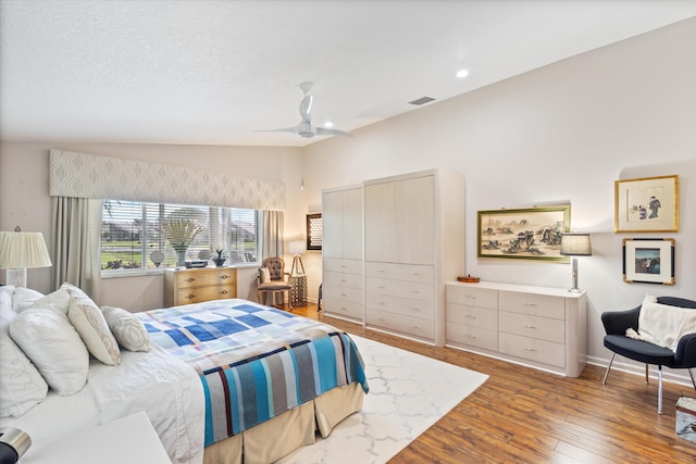 bedroom featuring visible vents, baseboards, lofted ceiling, ceiling fan, and light wood-type flooring