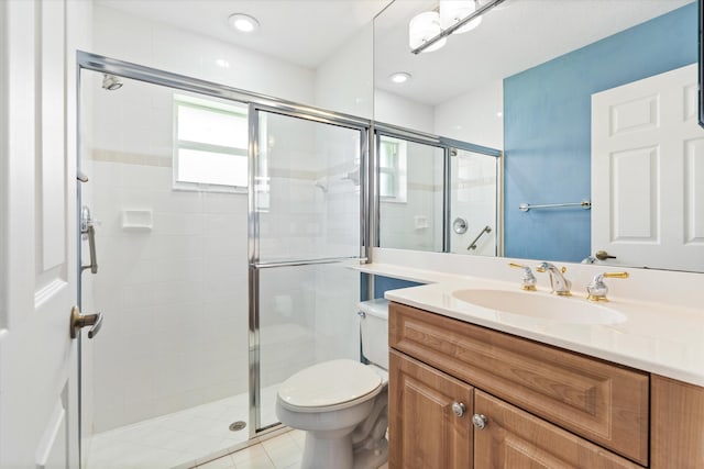 bathroom featuring vanity, a shower stall, toilet, and tile patterned floors