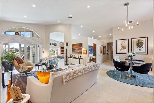 living area featuring a towering ceiling, baseboards, arched walkways, and recessed lighting