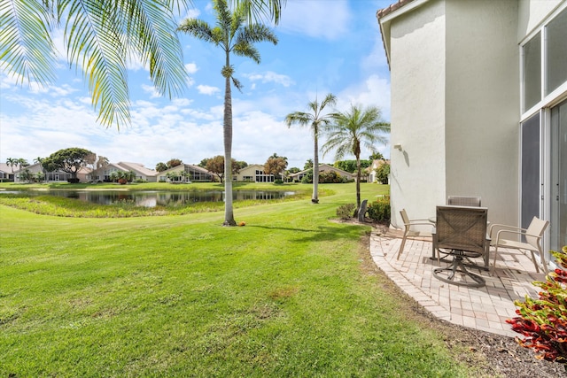 view of yard with a patio, a water view, and a residential view