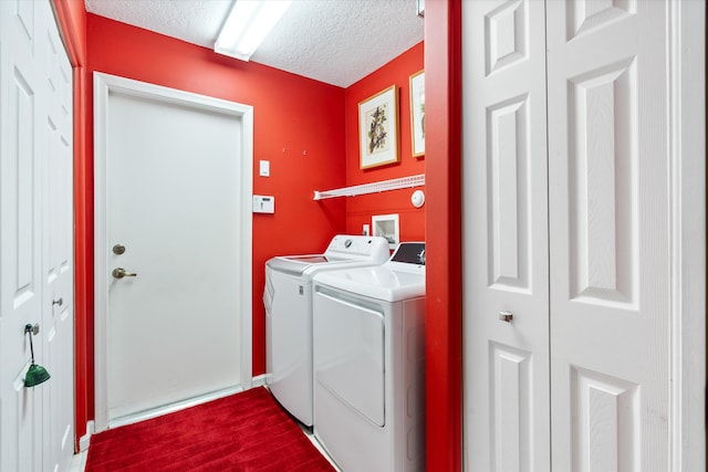 clothes washing area featuring dark wood-type flooring, washer and dryer, laundry area, and a textured ceiling