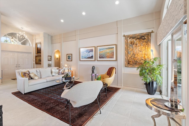 living area featuring arched walkways, light tile patterned floors, a high ceiling, and recessed lighting