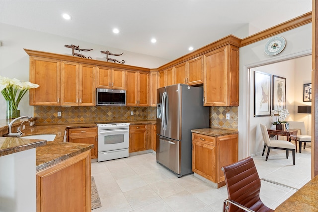 kitchen featuring stainless steel appliances, brown cabinetry, and a sink