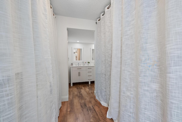 corridor featuring dark wood-style floors and a textured ceiling