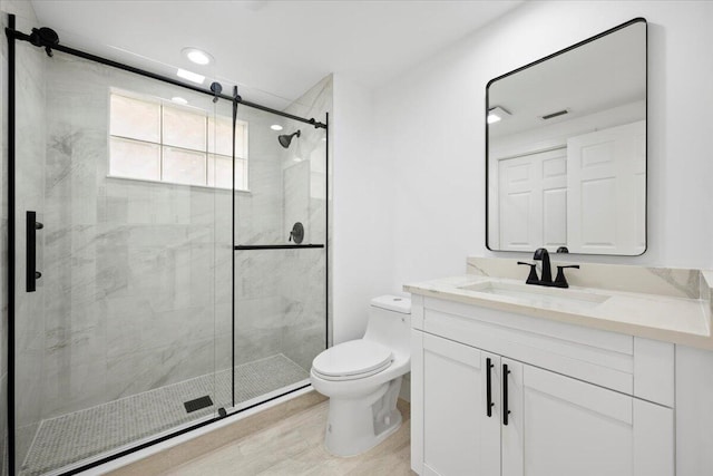 bathroom with toilet, a shower stall, visible vents, and vanity