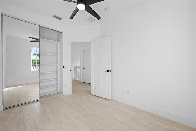 unfurnished bedroom with ceiling fan, a closet, visible vents, and wood finished floors