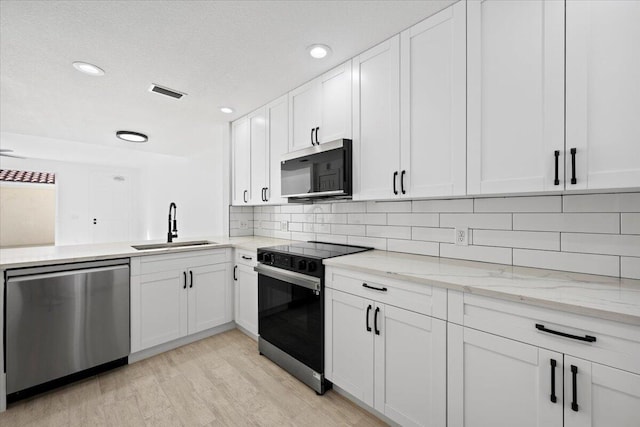 kitchen featuring electric range, a sink, white cabinetry, backsplash, and dishwasher