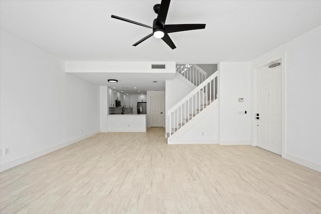 unfurnished living room featuring visible vents, baseboards, a ceiling fan, stairway, and light wood finished floors