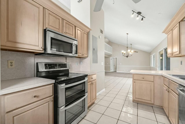 kitchen featuring decorative backsplash, lofted ceiling, stainless steel appliances, light countertops, and light brown cabinets