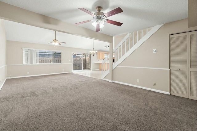 unfurnished living room with baseboards, lofted ceiling, a textured ceiling, carpet flooring, and ceiling fan with notable chandelier