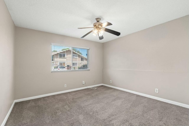 carpeted spare room with a textured ceiling, baseboards, and a ceiling fan