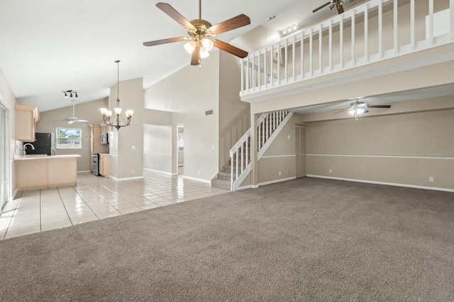 unfurnished living room featuring light tile patterned floors, ceiling fan with notable chandelier, light carpet, high vaulted ceiling, and stairs