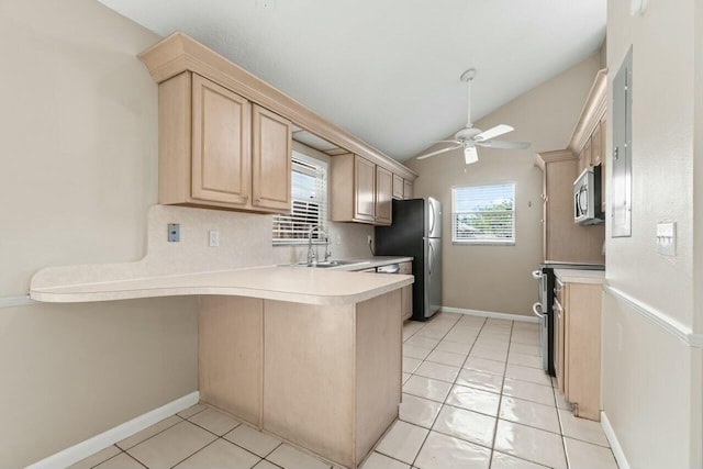 kitchen featuring light brown cabinets, a peninsula, a sink, a ceiling fan, and appliances with stainless steel finishes