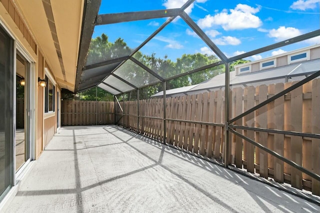 view of patio featuring glass enclosure and fence