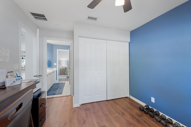 bedroom with ceiling fan, a closet, visible vents, and dark wood-type flooring