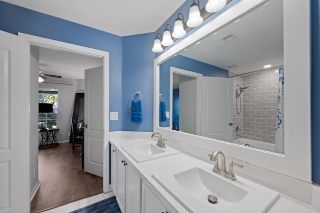 bathroom featuring shower / bath combo, visible vents, a sink, and wood finished floors