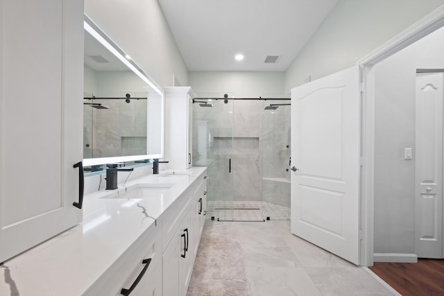 full bath with double vanity, a stall shower, a sink, and visible vents