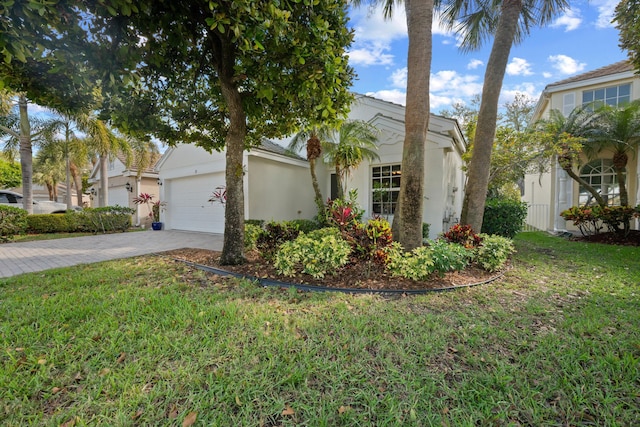 view of front of house with driveway, a front yard, an attached garage, and stucco siding