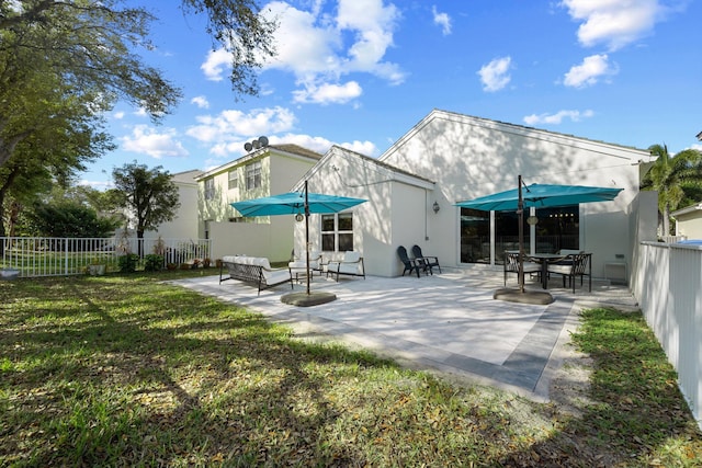 back of property with a patio area, fence, and a lawn