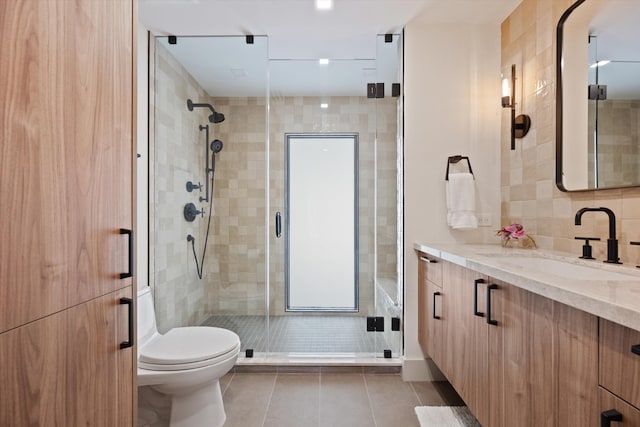 full bath with tile walls, toilet, a shower stall, vanity, and tile patterned floors