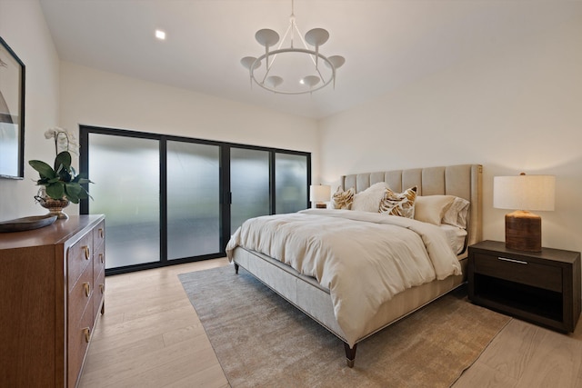 bedroom featuring light wood finished floors, access to outside, and an inviting chandelier