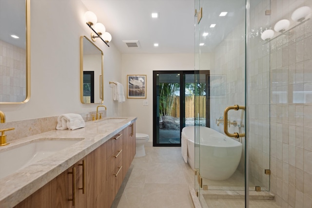 full bathroom featuring a freestanding tub, a sink, toilet, and double vanity