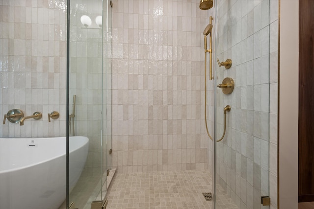 bathroom with a stall shower and a freestanding tub