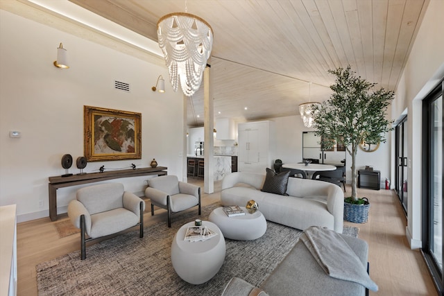 living room featuring a chandelier, light wood-style flooring, visible vents, wood ceiling, and baseboards