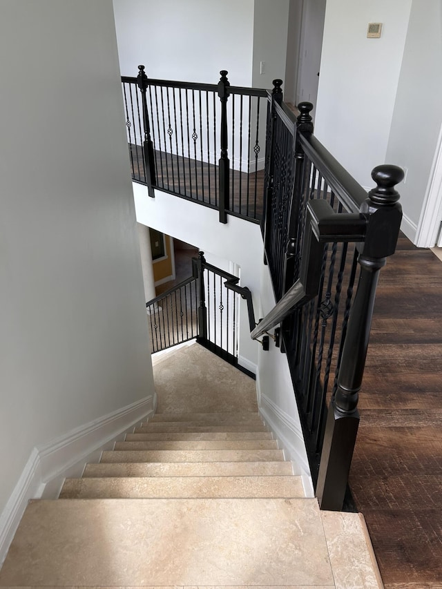 staircase with baseboards and wood finished floors