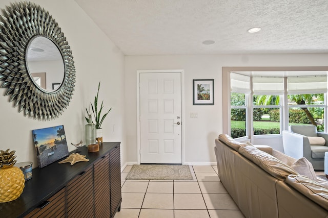 entrance foyer with light tile patterned floors, baseboards, and a textured ceiling