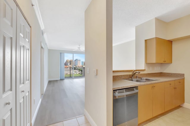 kitchen featuring ceiling fan, a city view, a sink, light countertops, and stainless steel dishwasher