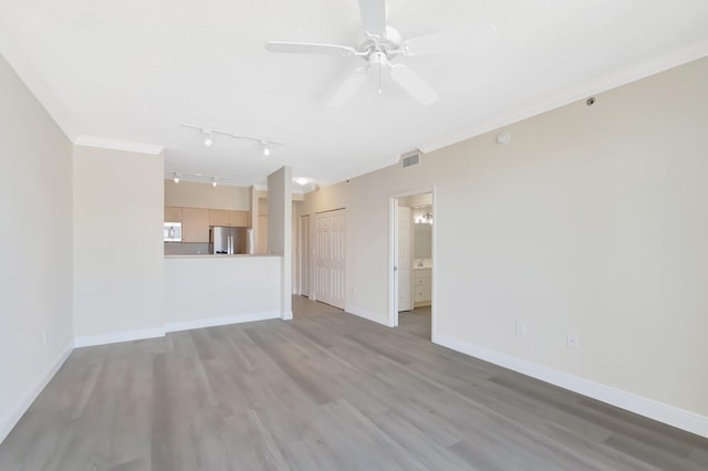 unfurnished living room featuring ornamental molding, light wood-type flooring, ceiling fan, and baseboards