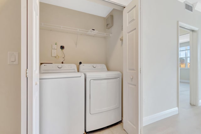 washroom with laundry area, baseboards, visible vents, and separate washer and dryer