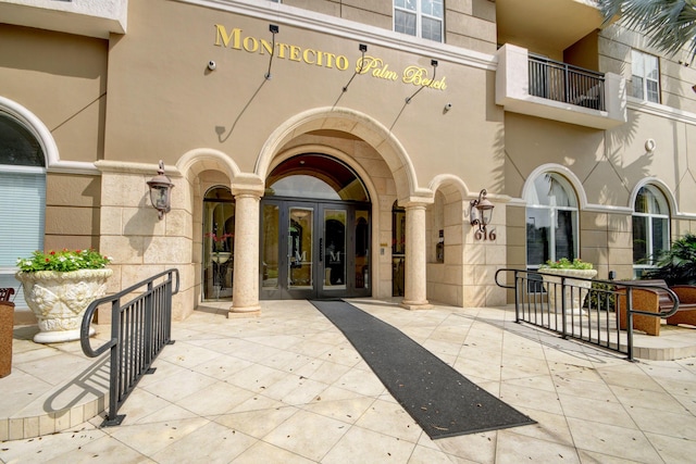 view of exterior entry with french doors and stucco siding