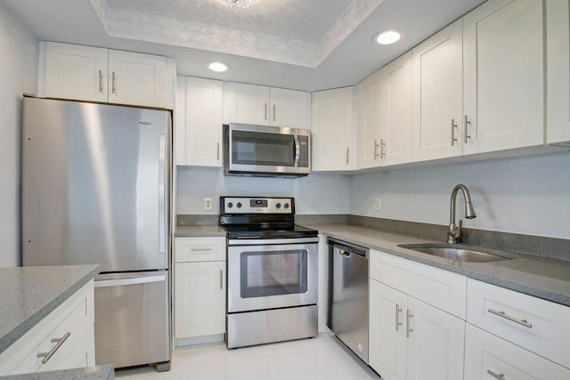 kitchen featuring appliances with stainless steel finishes, recessed lighting, white cabinets, and a sink