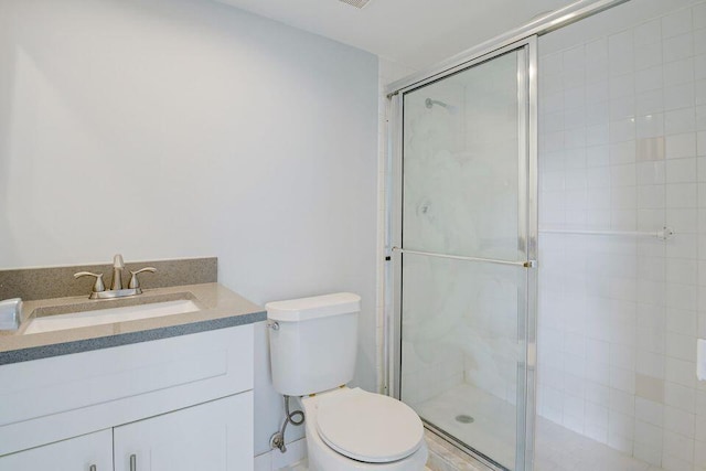 full bathroom with toilet, a stall shower, and vanity