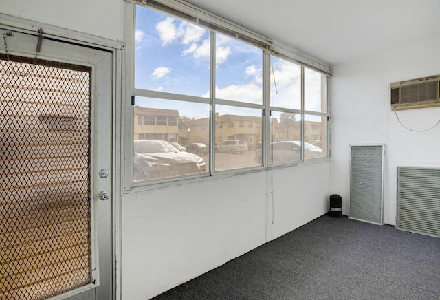 unfurnished sunroom with an AC wall unit