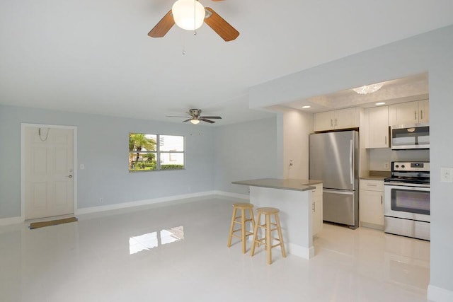 kitchen featuring a breakfast bar area, light tile patterned flooring, stainless steel appliances, white cabinetry, and open floor plan