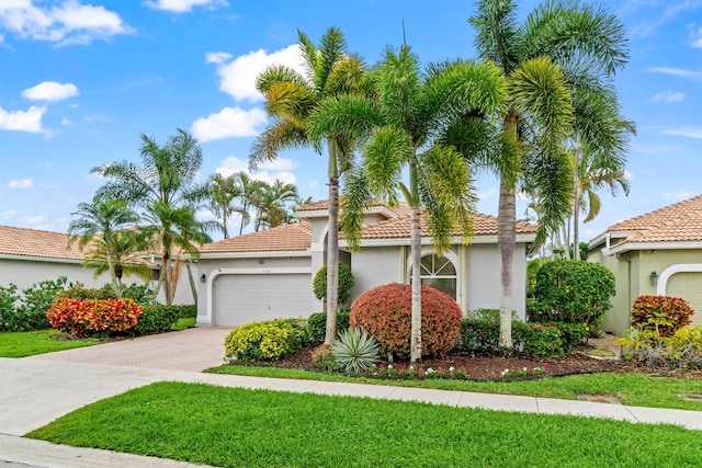 view of front of home featuring driveway, an attached garage, a tile roof, and stucco siding