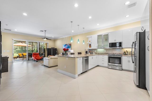 kitchen featuring a peninsula, open floor plan, appliances with stainless steel finishes, tasteful backsplash, and crown molding