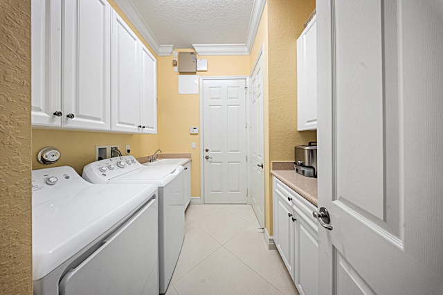 laundry area with cabinet space, light tile patterned floors, ornamental molding, independent washer and dryer, and a textured ceiling