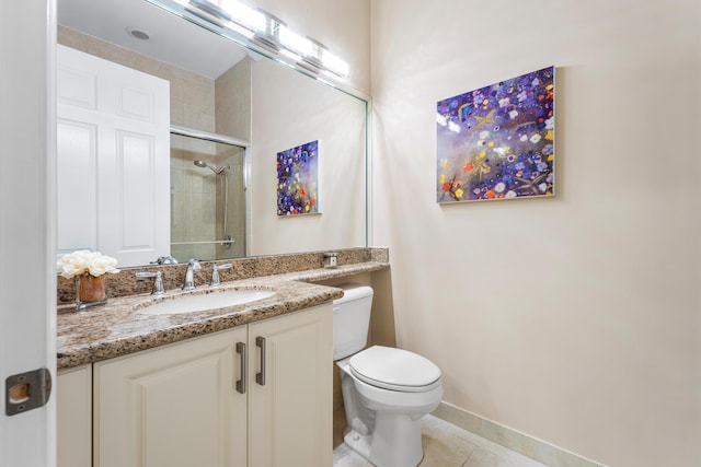 full bath featuring toilet, vanity, baseboards, tiled shower, and tile patterned floors