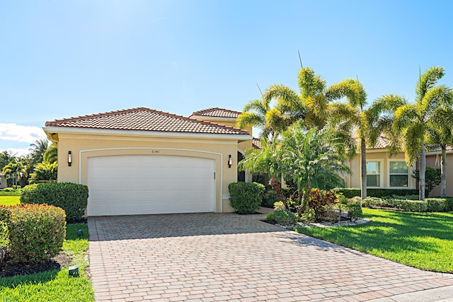 view of front of property featuring a tiled roof, a front lawn, decorative driveway, and stucco siding