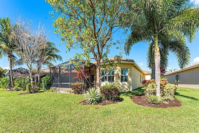 exterior space featuring a lanai, a lawn, and stucco siding