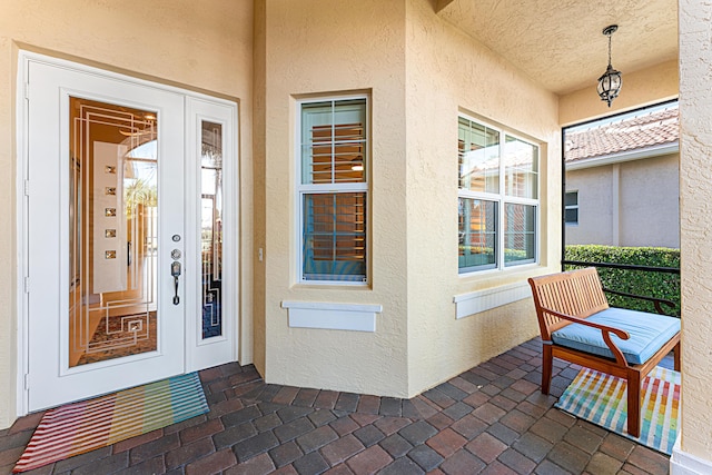 property entrance with covered porch and stucco siding