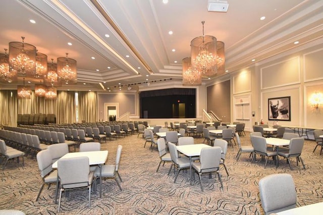 dining space featuring a chandelier, recessed lighting, a decorative wall, ornamental molding, and a tray ceiling