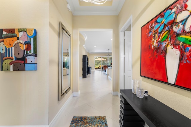 hallway with tile patterned flooring, ornamental molding, and baseboards